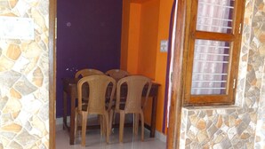 A small room with a purple floor, a window with bars, and a wooden bench. - For Delightful stay visit us. (Madikeri)