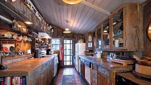 Una cocina con armarios de madera, una isla central y varios electrodomésticos.