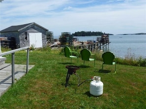 Enjoy a serene lakeside retreat with a cozy cabin, outdoor seating area, and tranquil views of the lake.