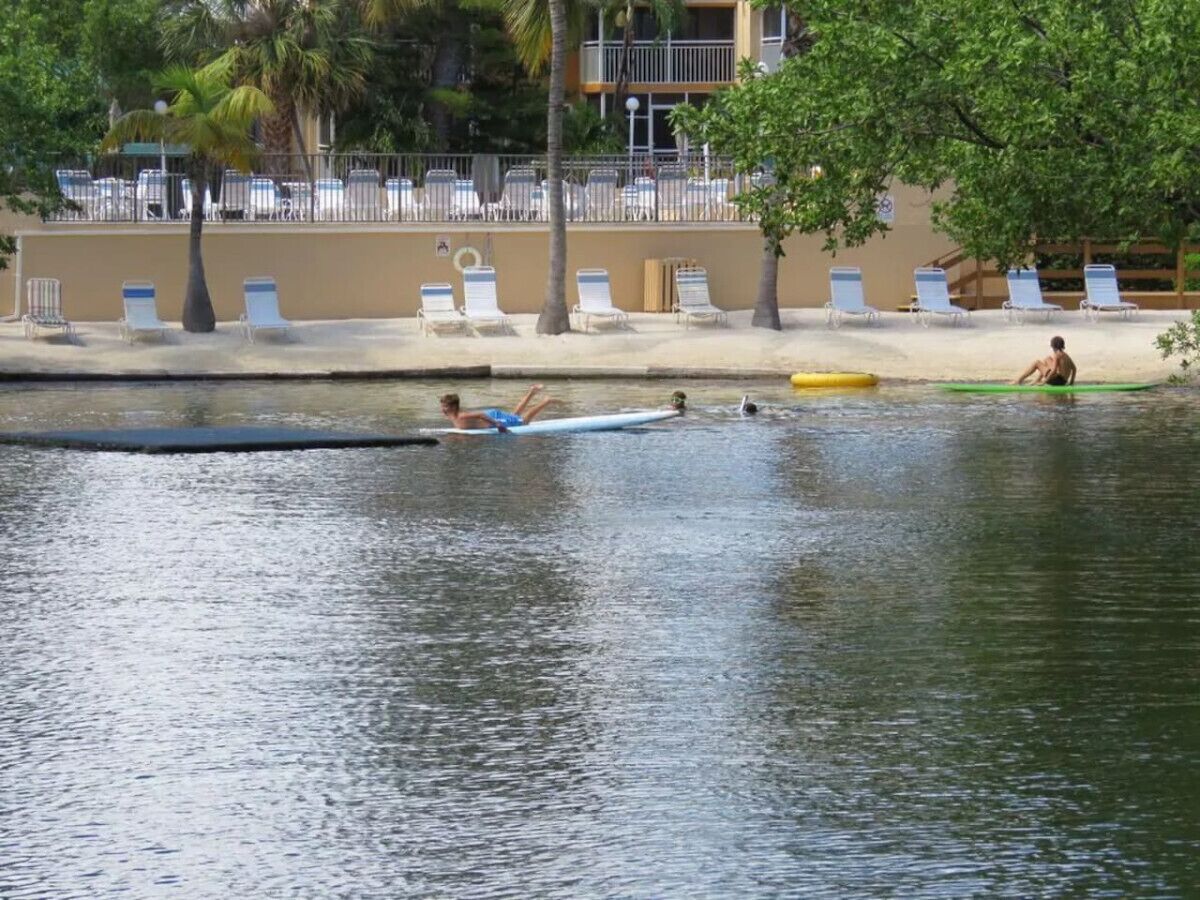 Una zona frente al agua con sillones de descanso y una piscina.