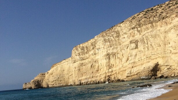 A beach with clear blue water, sandy shore, and a rocky cliff. - villa fully equipped with swimming pool and sea view and 360 °  (kamilari)