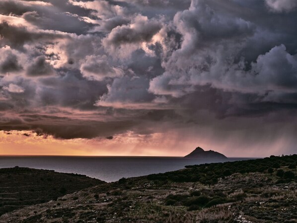 A coastal landscape with a mountain in the distance, under a dramatic sky with clouds. - villa fully equipped with swimming pool and sea view and 360 ° (kamilari)