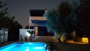A modern house with a swimming pool, a staircase leading to the entrance, and potted plants around the area. - villa fully equipped with swimming pool and sea view and 360 °  (kamilari)