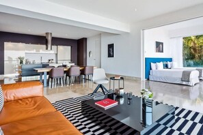 Una sala moderna con sofá, mesa de centro y un comedor con sillas.