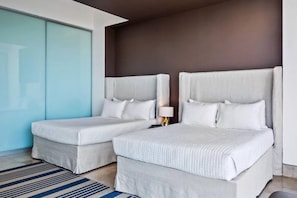 Ett hotellrum med två sängar, ett stort fönster och en skjutdörr.