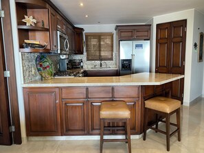 Enjoy cooking in this well-equipped kitchen with a central island, sink, and stainless steel appliances.