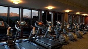 A gym with treadmills and elliptical machines, large windows with a mountain view, and ceiling lights. - Breckenridge Christmas & New Year weeks 2021-2022 email (Breckenridge)