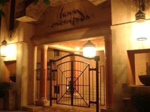 Enter through the historic stone archway, flanked by columns, and into a traditional hotel.
