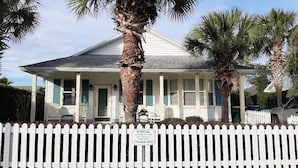 A white house with a picket fence, palm trees, and a sign advertising Sundial. - SUNDIAL COTTAGE: CRYSTAL BEACH, DESTIN, FL.  PRIVATE POOL!     (Destin)