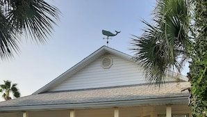 A single-story house with a covered porch, numbered 4485D, featuring a weather vane, green shutters, and white siding. - SUNDIAL COTTAGE: CRYSTAL BEACH, DESTIN, FL.  PRIVATE POOL!     (Destin)