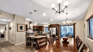 A spacious kitchen with wooden cabinets, a large island, and a dining area with a long table and chairs.