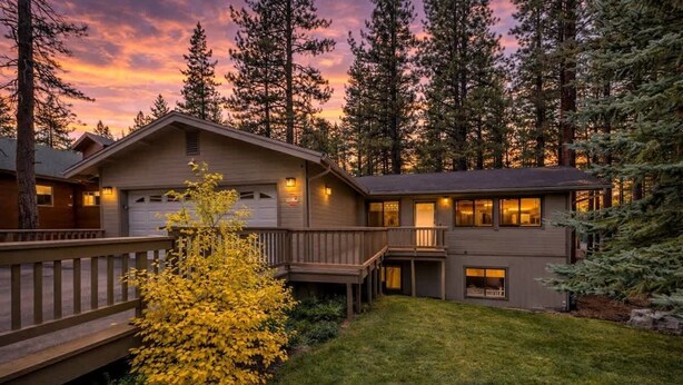 A two-story lodge with a deck, a garage, and a small porch.