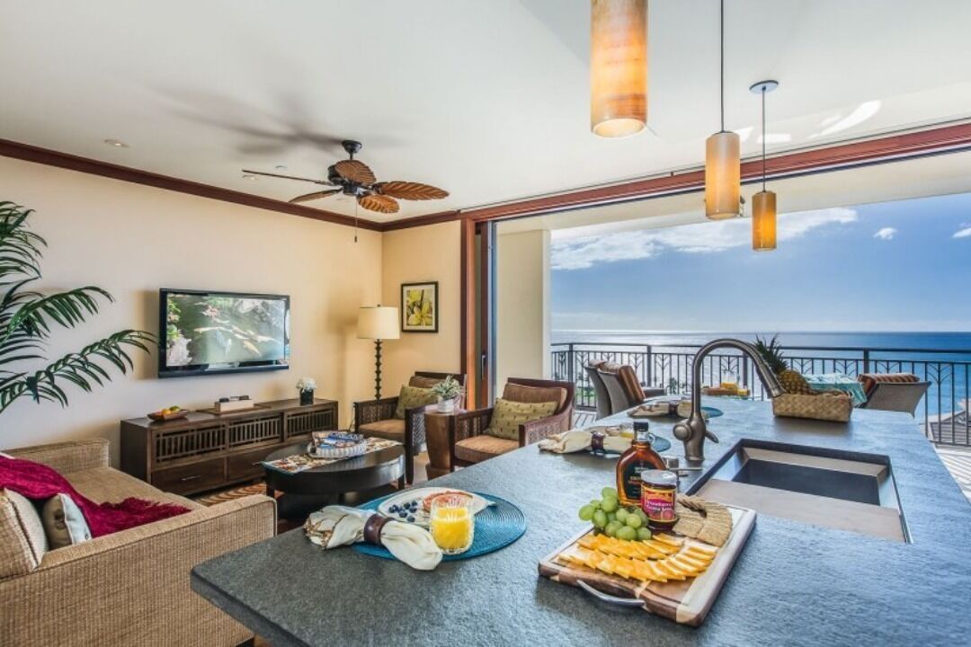 Una sala de estar moderna con comedor, ventanas amplias y vista al océano.