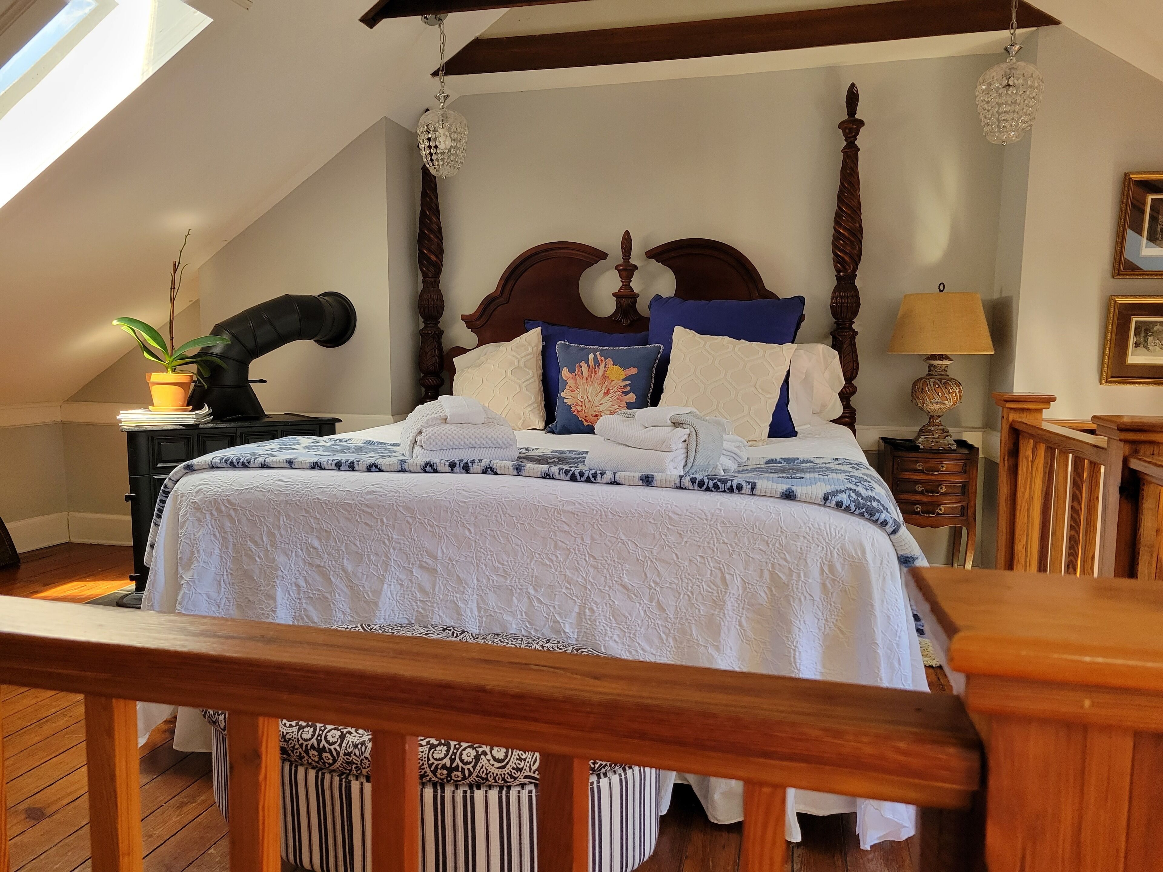 A bedroom with a large bed, wooden headboard, and a skylight.