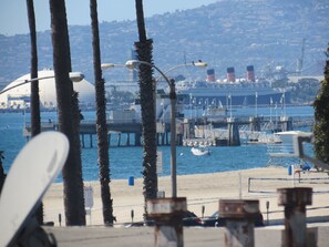A coastal scene with a pier, boats, and a beach.