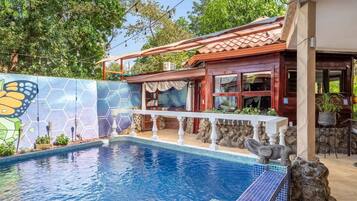 Enjoy a pool surrounded by a deck and garden with a mural.