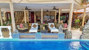 A pool area with lounge chairs and a bar area in the background. - Casa Melosa Villa in Playa Potrero/Flamingo Costa Rica (Playa Potrero/Flamingo)