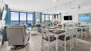Une chambre d’hôtel spacieuse, dotée d’un grand coin repas, d’un canapé et offrant une vue sur l’océan.