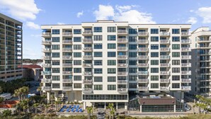 Un hôtel à plusieurs étages doté de balcons, d’un espace piscine et offrant une vue sur la plage.
