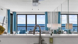 Une salle de bain moderne avec une grande fenêtre, un lavabo et un miroir.
