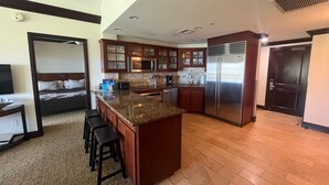 A modern kitchen with granite countertops, stainless steel appliances, and wooden cabinets. - AMAZING PRIME OCEANVIEW 2 BDRM, 3 BATH PENTHOUSE (Kapaa)