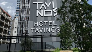 Un moderno edificio de hotel con un letrero llamativo que dice "TAVINOS HOTEL".