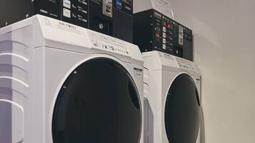 Two front-loading washing machines with control panels and safety instructions.