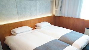 A double bed with white linens and gray accents, wooden headboard, and a stone wall. - Hotel Oriental Express Tokyo Kamata (Tokyo)
