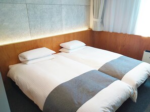 A double bed with white linens and gray accents, wooden headboard, and a stone wall. - Hotel Oriental Express Tokyo Kamata (Tokyo)