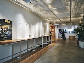 Un interior moderno con una larga recepción, estanterías metálicas y un techo con diseño de cuadrícula.