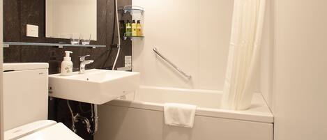 A modern bathroom with a toilet, sink, and bathtub.