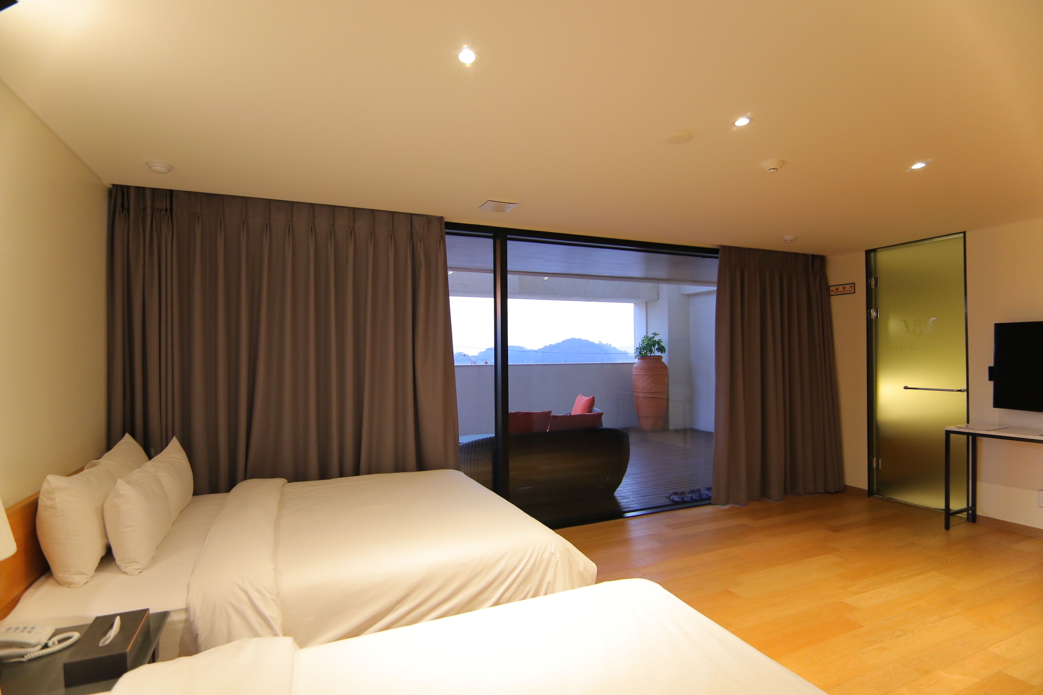 Habitación de hotel con una cama grande, un escritorio y un balcón con vistas.