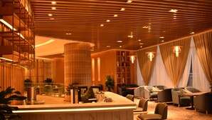 A modern hotel lobby with a reception desk, seating area, and a large column. - Galaxy Minyoun Langzhong Tianfu Hotel (Nanchong)