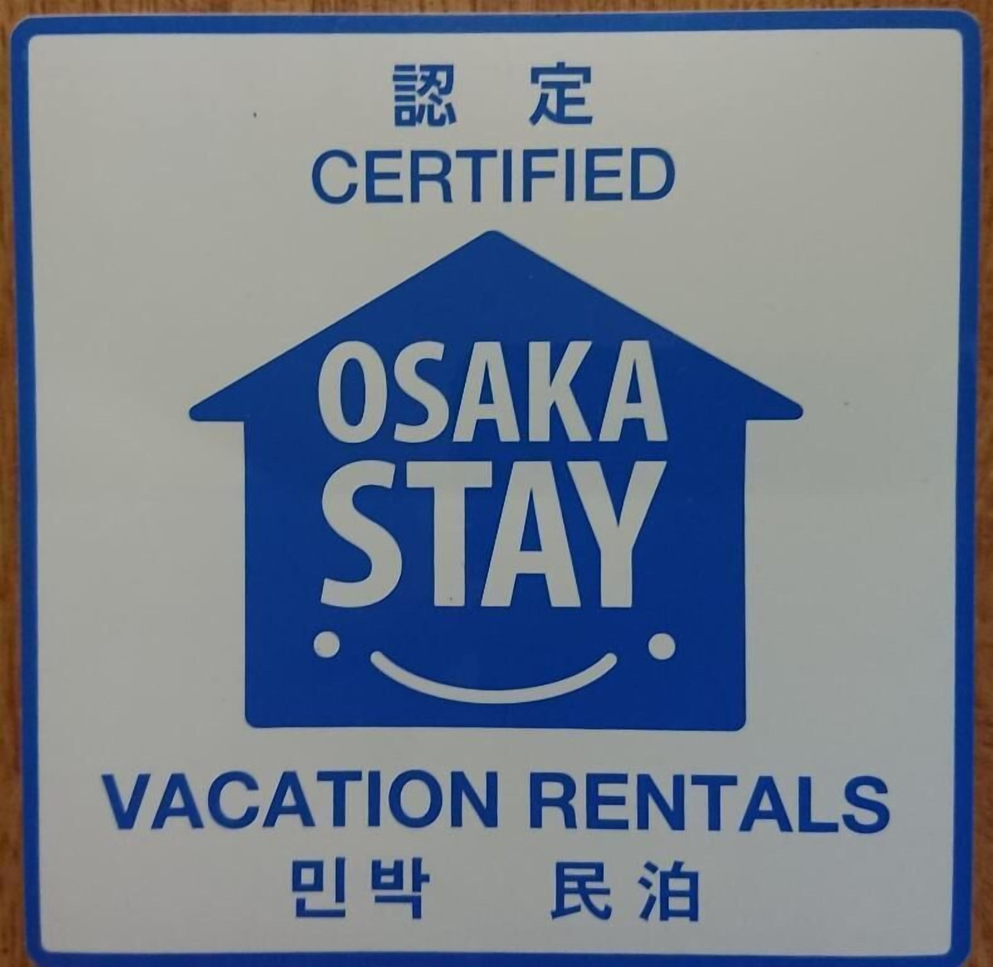 A sign for certified vacation rentals in Osaka.