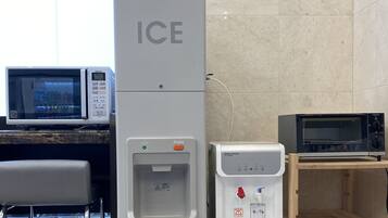 A kitchenette with a microwave, a water dispenser, and a toaster.