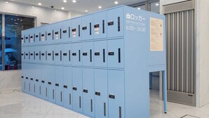 A row of blue self-service lockers with a sign indicating they are available from 6:00 to 24:00. - Toyoko Inn Odawara Station (Odawara)