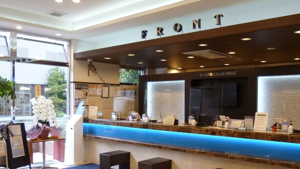 A reception area with a blue counter, a sign reading "FRONT", and a logo on the floor. - Toyoko Inn Odawara Station (Odawara)