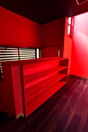A room with red walls, a wooden floor, and a window with blinds. - Machi de kurasu Tengachaya-3 (Osaka)