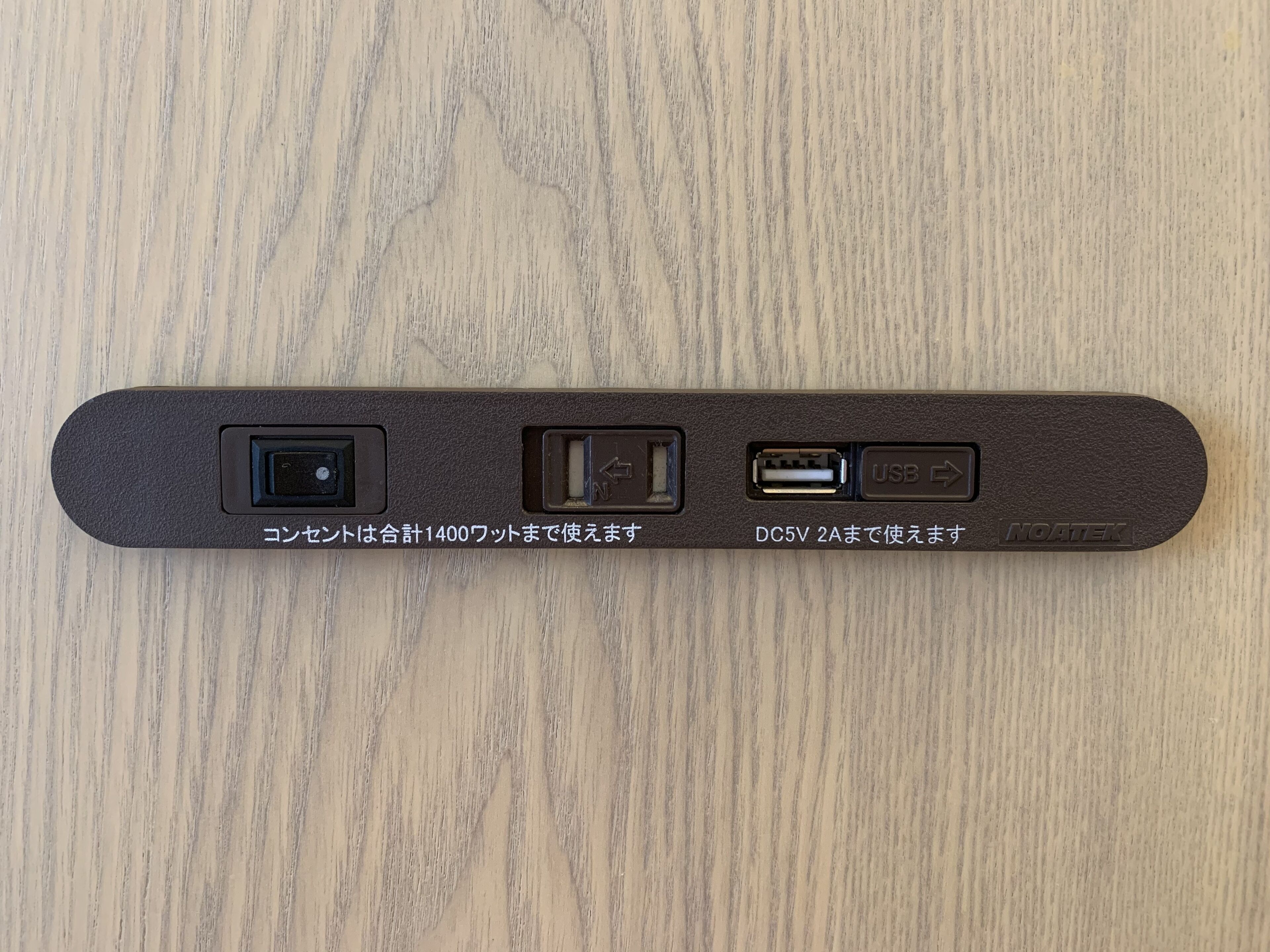 A power strip with multiple ports, including USB and DC inputs, on a wooden surface.
