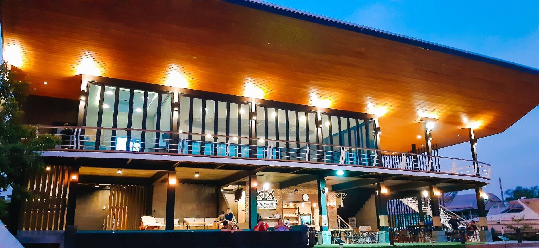Een modern gebouw met een overdekt terras en een balkon op de tweede verdieping.