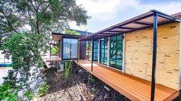 Una casa moderna con terraza de madera, ventanas amplias y fachada de ladrillo.