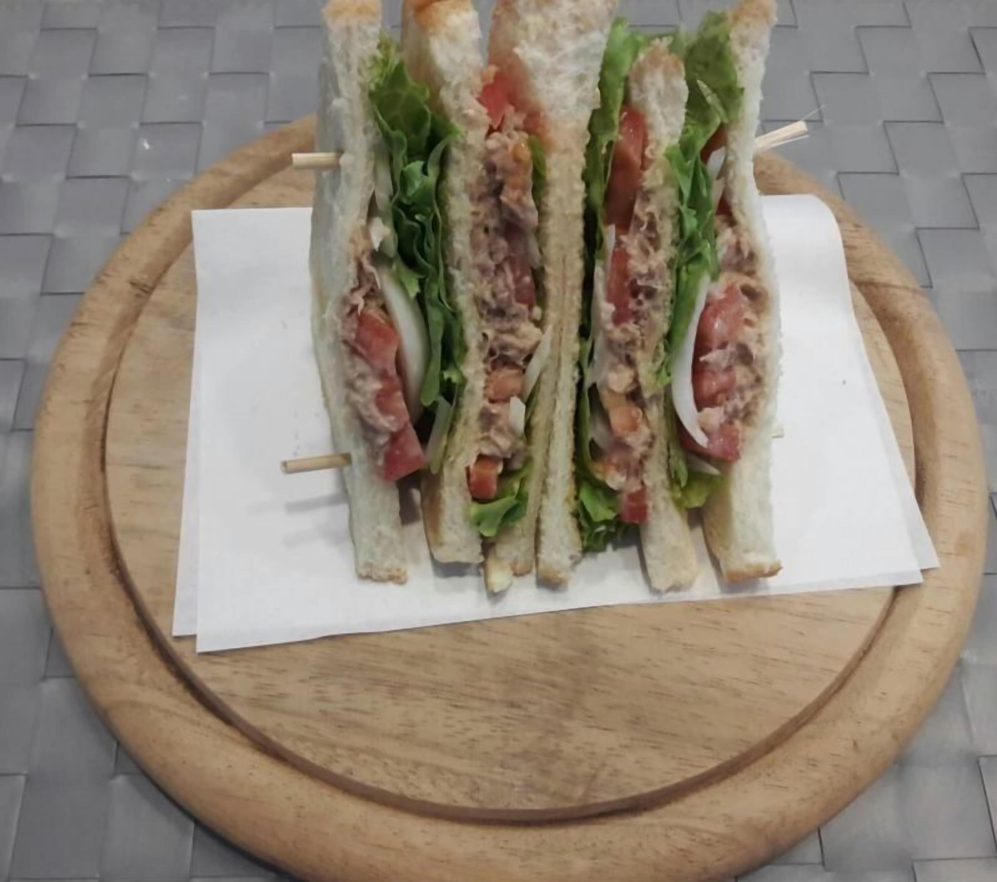 A sandwich on a wooden board.