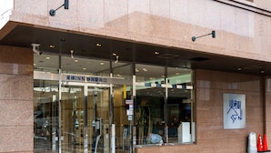A hotel entrance with a glass door, signage in a foreign language, and a wheelchair-accessible ramp. - Toyoko Inn Shizuoka Station (Shizuoka)