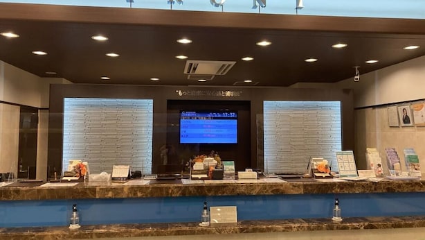 A reception area with a digital display, a marble counter, and a sign above reading "FRONT". - Toyoko Inn Shizuoka Station (Shizuoka)