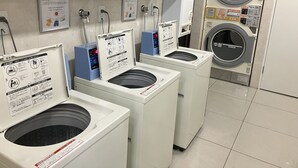 A laundry facility with multiple washing machines and dryers, each with safety instructions and operational guidelines. - Toyoko Inn Shizuoka Station (Shizuoka)