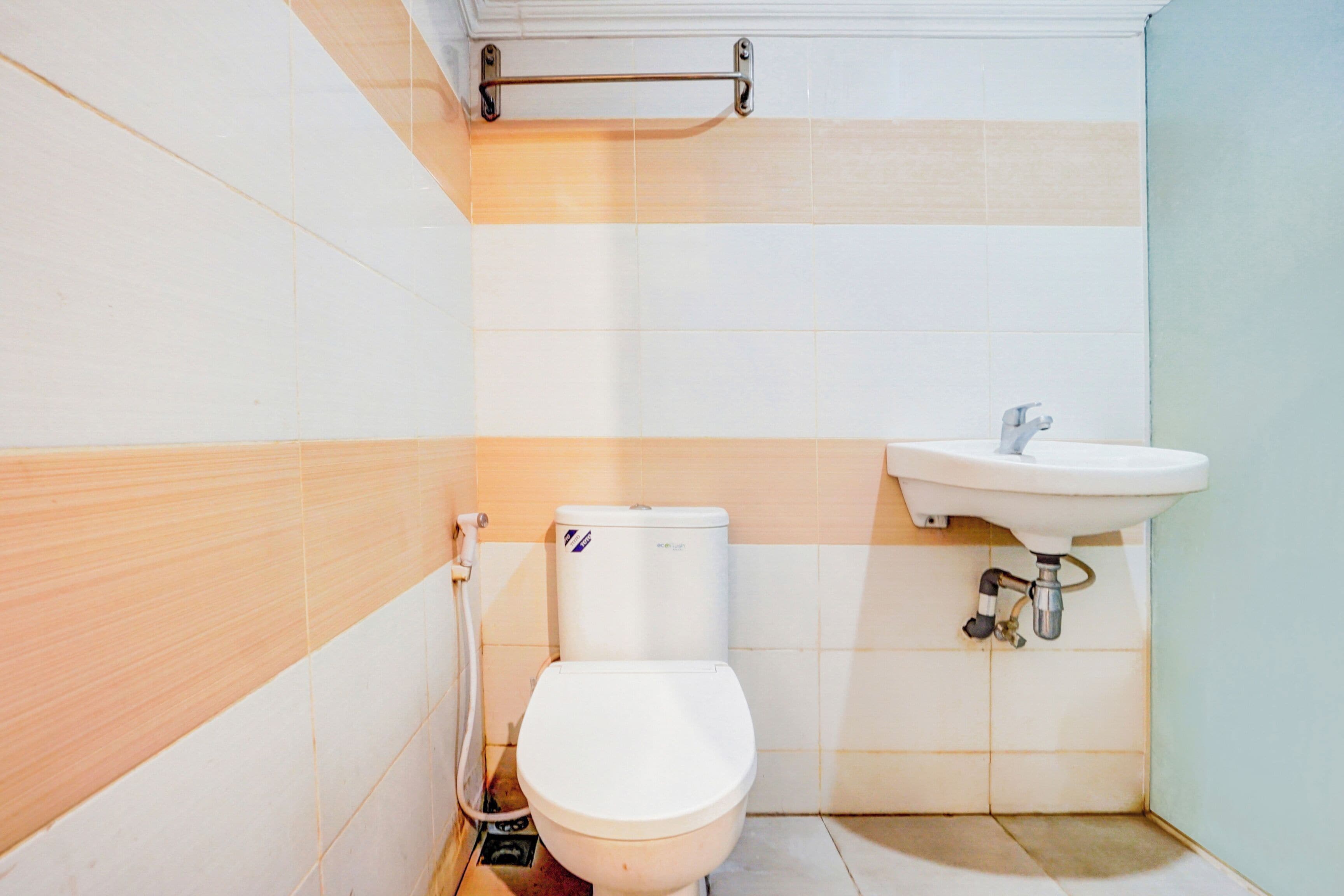 A small bathroom with a toilet, sink, and a towel rack.