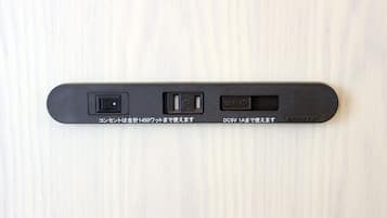 A black device with three ports on a light wooden surface.
