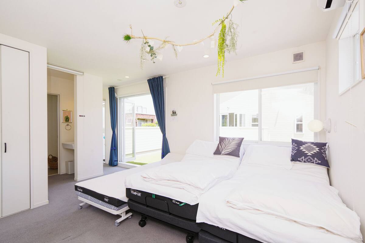 A modern bedroom with a bed, a window, and a view of the outside.