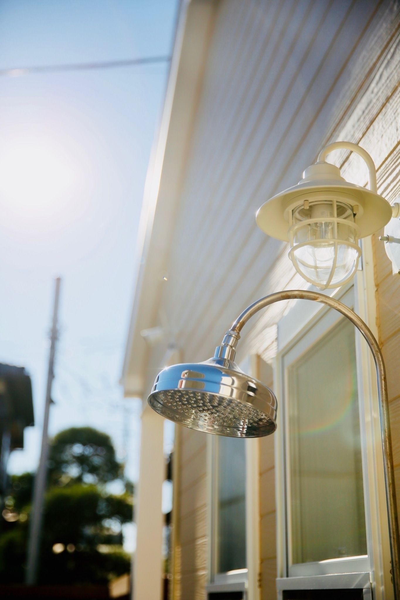 A metal showerhead attached to a building's exterior wall.