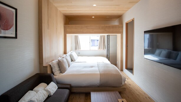 Quarto moderno com uma cama grande, um sofá e uma televisão.